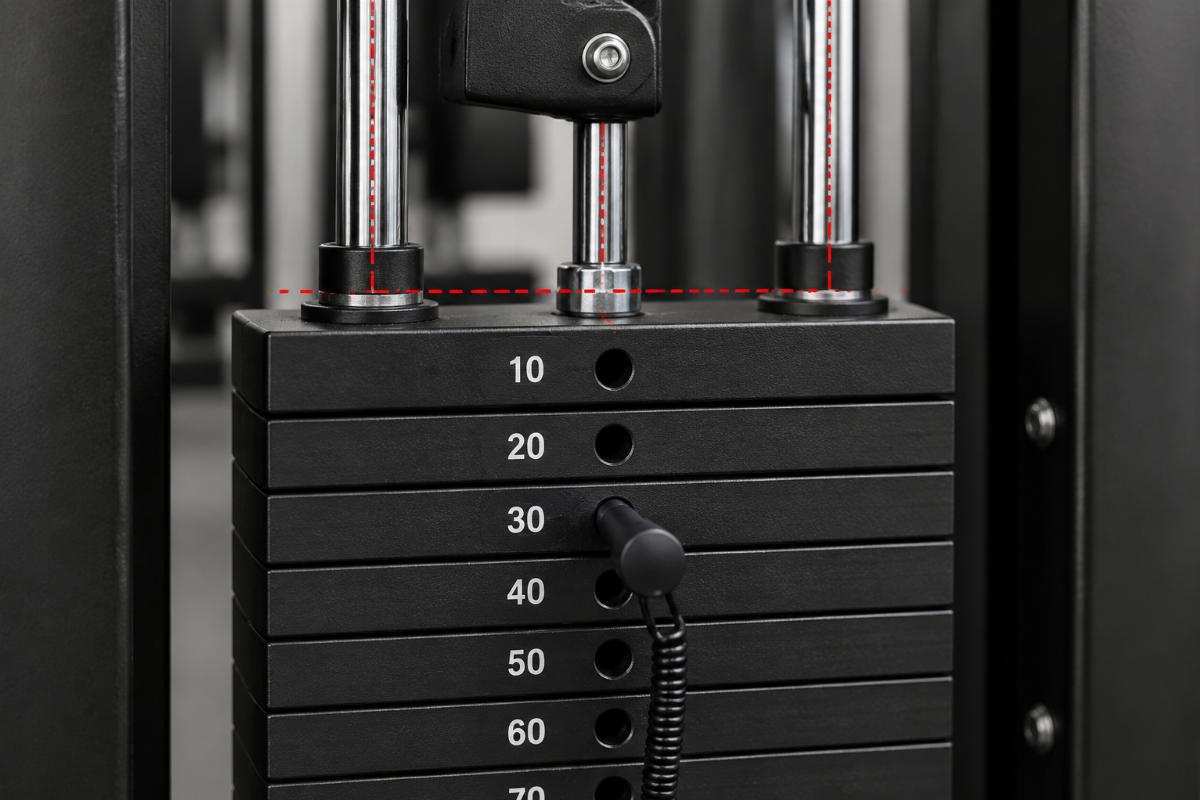 Close-up inspection of weight stack guide rods and pin hole alignment on selectorized machine