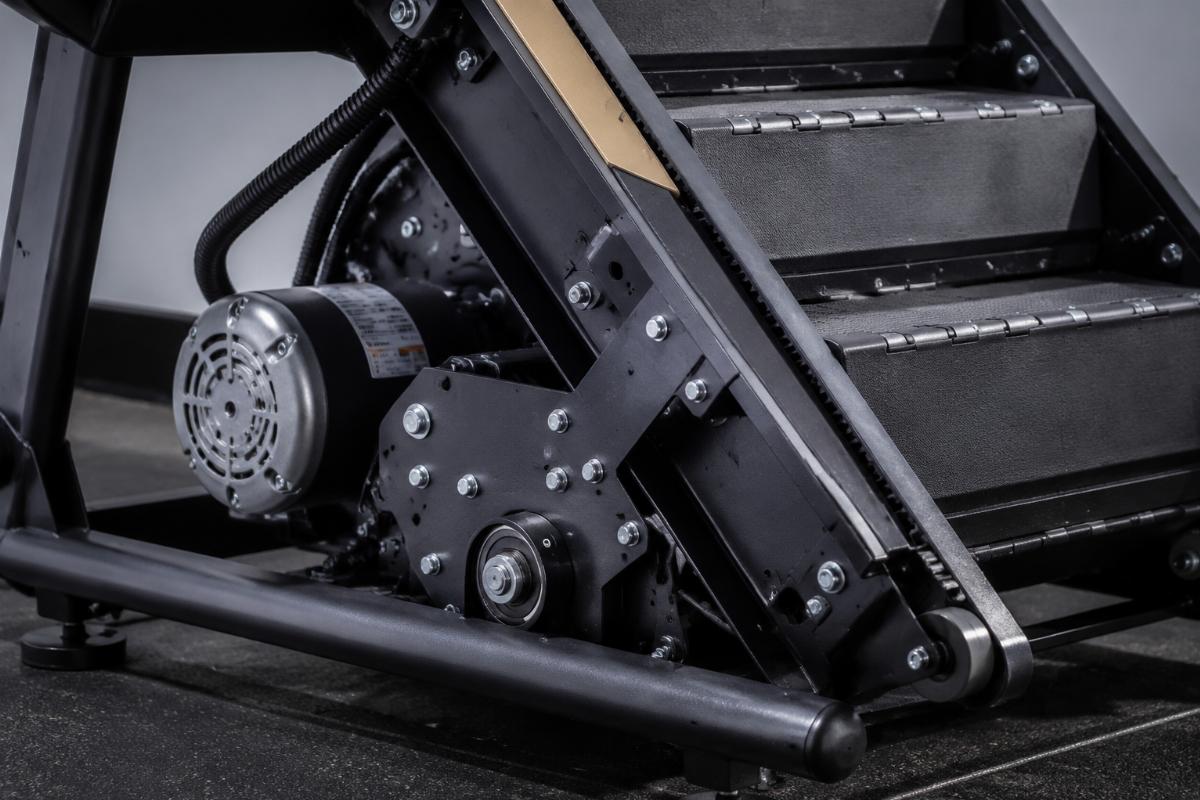 Close-up of a commercial stair climber frame and motor assembly showing heavy-duty construction